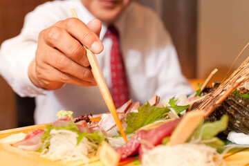 お刺身を食べるビジネスマン