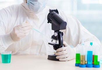 Young chemist student working in lab on chemicals