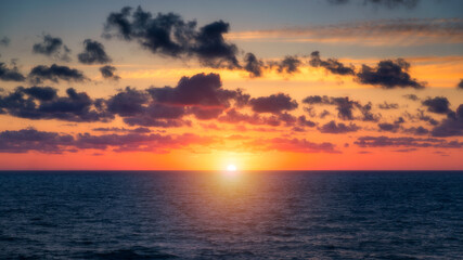 Naklejka na ściany i meble Beautiful sunset/sunrise over the sea. Beautiful sunset over the ocean. Beautiful sunset over sea with reflection in water, majestic clouds in the sky