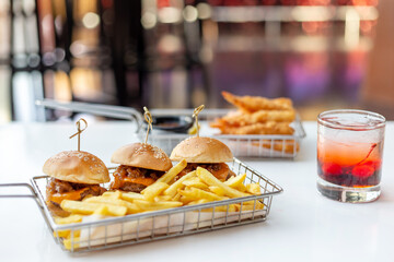 Mini burgers with french fries and cocktail served at the bar, finger food