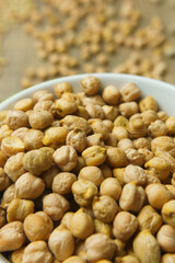 garbanzos en pocillo de color blanco sobre madera 