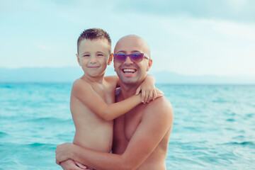 Son and father smiling, embracing each other, outdoors