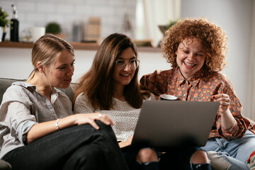 Happy businesswomen talking and laughing in office. Beautiful women drinking coffee in the office