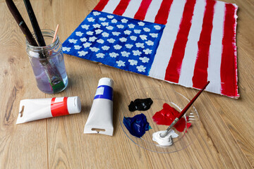 Fototapeta na wymiar DIY Painting American Flag on Cardboard with tubes of paint and brushes