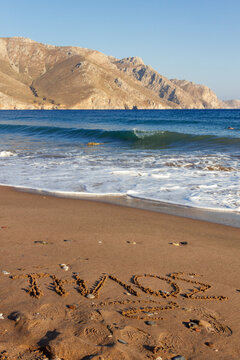 Tilos, the name of the island written on the sand in Eristos beach, in Tilos, Greece, Europe.