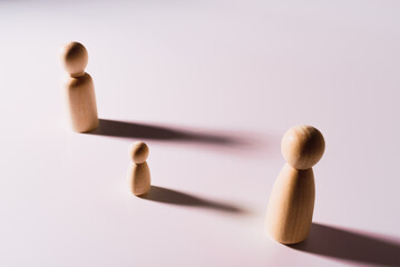 Minimalistic social loneliness concept with wooden figures on white background.