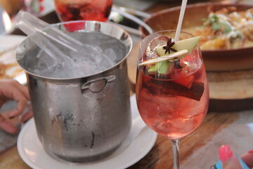 sangria servida en copa bien fria con cortes de manzana verde, bebidas entre amigos,  estilo de vida