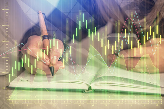 Double exposure of businesswoman hands typing on computer and forex graph hologram drawing. Financial analysis concept.