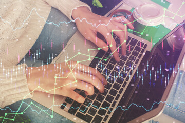 Double exposure of woman hands typing on computer and forex chart hologram drawing. Stock market invest concept.