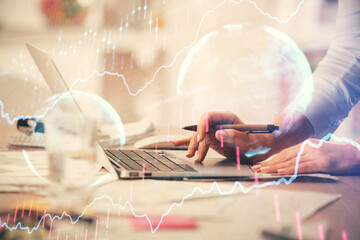 Double exposure of woman hands typing on computer and forex chart hologram drawing. Stock market invest concept.