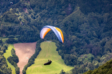 Paragliding in paradise landscape with volcano crater and lagoon in Azores. Paraglider above Lagoa das Furnas, Sao Miguel, Azores, Portugal, Europe