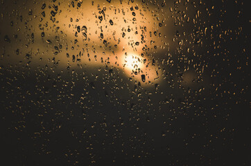 The setting sun behind a rainy window.