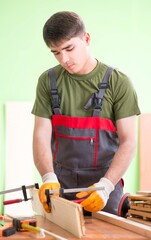 Young man carpenter working in workshop