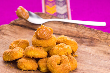 Deliciosas rosquitas y rosquillas con dulce manjar blanco  en mesa de madera rústica de los andes del Perú