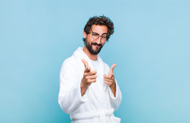 young bearded man wearing a bath robe feeling happy, cool, satisfied, relaxed and successful,...