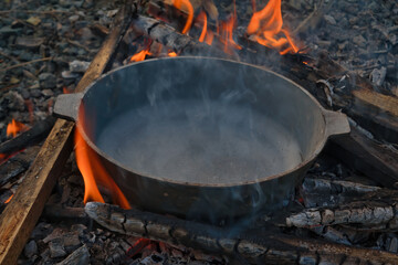 Empty black cast-iron frying pan on a fire close-up.