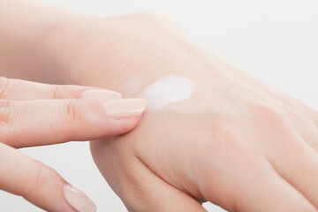 クリームを塗る女性の手元