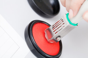 判子に朱肉をつける女性の手元