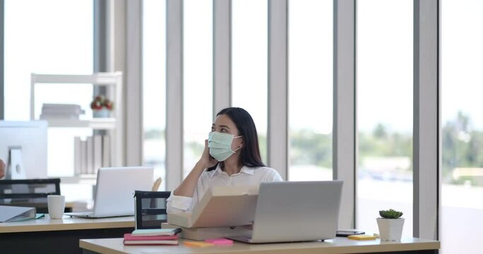 Two young business man and woman eating pizza for lunch while working.