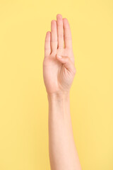 Hand showing letter B on color background. Sign language alphabet