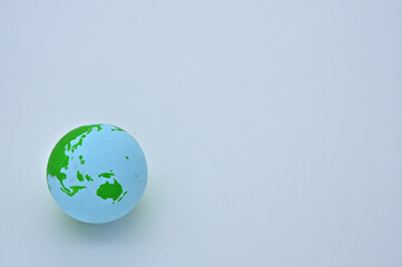 The ball of the earth is on a wooden board, and the Pacific Ocean is visible.