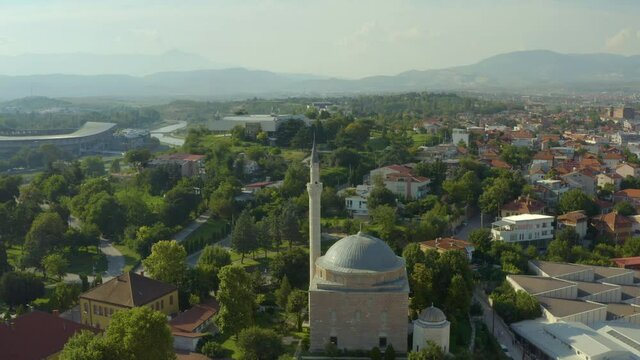 
Drone video of a mosque standing in the historic center where there are many narrow streets and houses with red roofs. Aerial view of Skopje Macedonia.