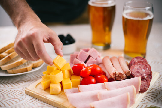 Selecci&oacute;n de fiambres en tabla de madera de lomo ahumado, lomo cocido, jam&oacute;n cocido, queso, salame de mil&aacute;n, acompa&ntilde;ado de aceitunas y cerveza