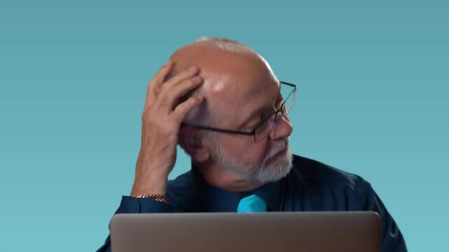 Funny business man has problem and yells at computer, furious in rage and anger, bites his computer and then pets his computer. Closeup portrait on blue.