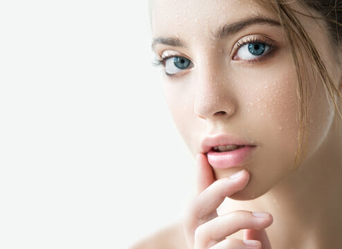 Beautiful Young Woman With Clean Perfect Skin And Water Moisture Drops Touching Face.