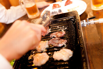 肉を焼く女性の手元