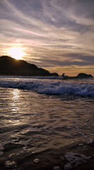 surfing the waves at sunset on the beach