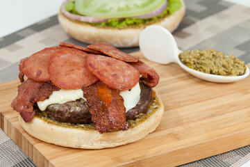 Slice Of Hamburger Bun With Salami, meat, And Sauce; Ready To Assemble The Burger.