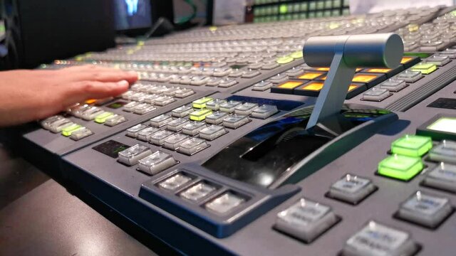 Hands on dissolve of Switcher buttons in studio TV station, Audio and Video Production Switcher of Television Broadcast.

