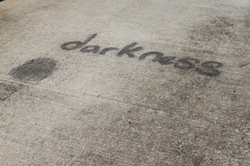 Cement pathway with darkness inscribed in black on it