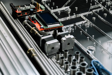 a set of parts for a laser machine on a black background, silver backlight, flat lay arduino board for controlling the machine and v slot aluminum profile lies .