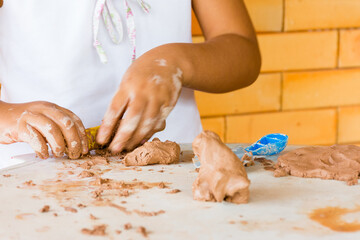 Mãos de criança modellando massa de argila - obrazy, fototapety, plakaty