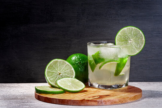 brazilian caipirinha on a cutting board with lemon with a gradient background, copy space
