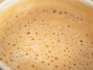 Texture of coffee foam. Close-up top-down view.