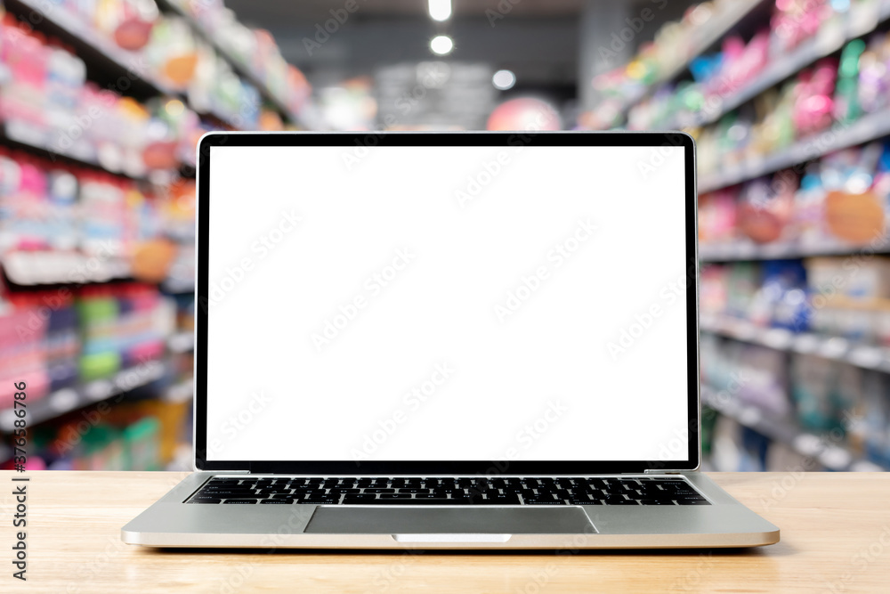 Fototapete laptop blank screen on wood table with supermarket in department store background, mockup, template 
