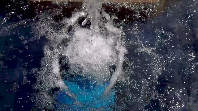 Water splashing creating bubbles and foam on water surface slow motion
