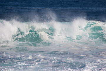 Naklejka premium Huge frothy waves of the Indian Ocean rolling in at famous Yallingup Beach,South Western Australia a world famous surfing mecca, on a cold yet sunny late winter morning.