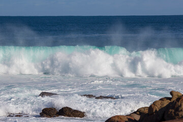 Huge  frothy waves of the Indian Ocean rolling in at famous Yallingup Beach,South Western Australia a world famous surfing mecca, on a cold yet sunny late winter morning.