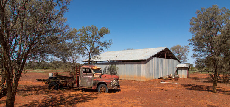 Australian Outback scene with abandoned truck and shed in the background.