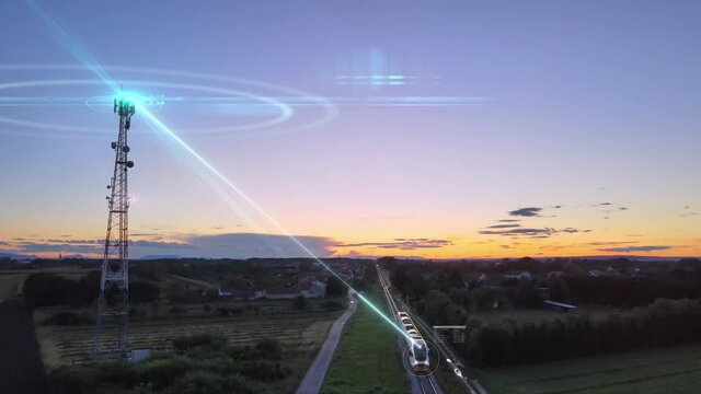 Aerial view of 5G tower antenna. Microwave graphic effect control a fast train passing through the village during the Sunset. Conspiracy big brother new normal concept.