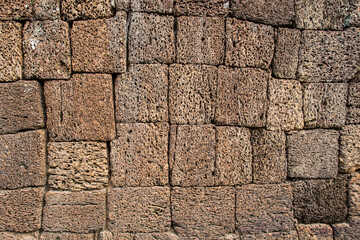 Fragment of a wall made of stones of different shapes with a porous texture