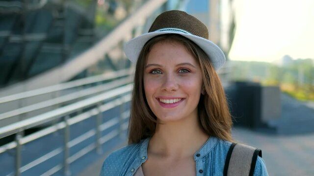 Portrait of happy smiling tourist beautiful woman traveler girl standing outdoors street or airport, travelling travel, Cute female looking at camera, attractive young girl enjoying summer 4 K slow-mo