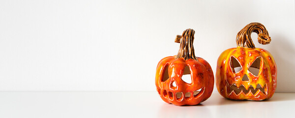 Ceramic Jack Lanterns on table wall background. Minimal home decor, banner format