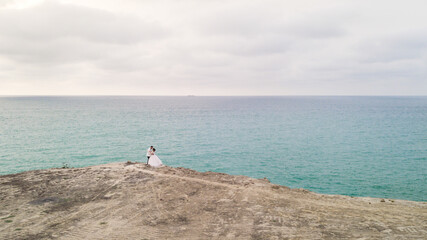 Bride and Groom with white tuxedo holding each other outdoor posing