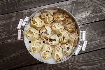 Ready-made hot manti in an aluminum cooker.