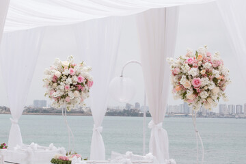 Beautiful white and pink flower centerpiece with ocean in background